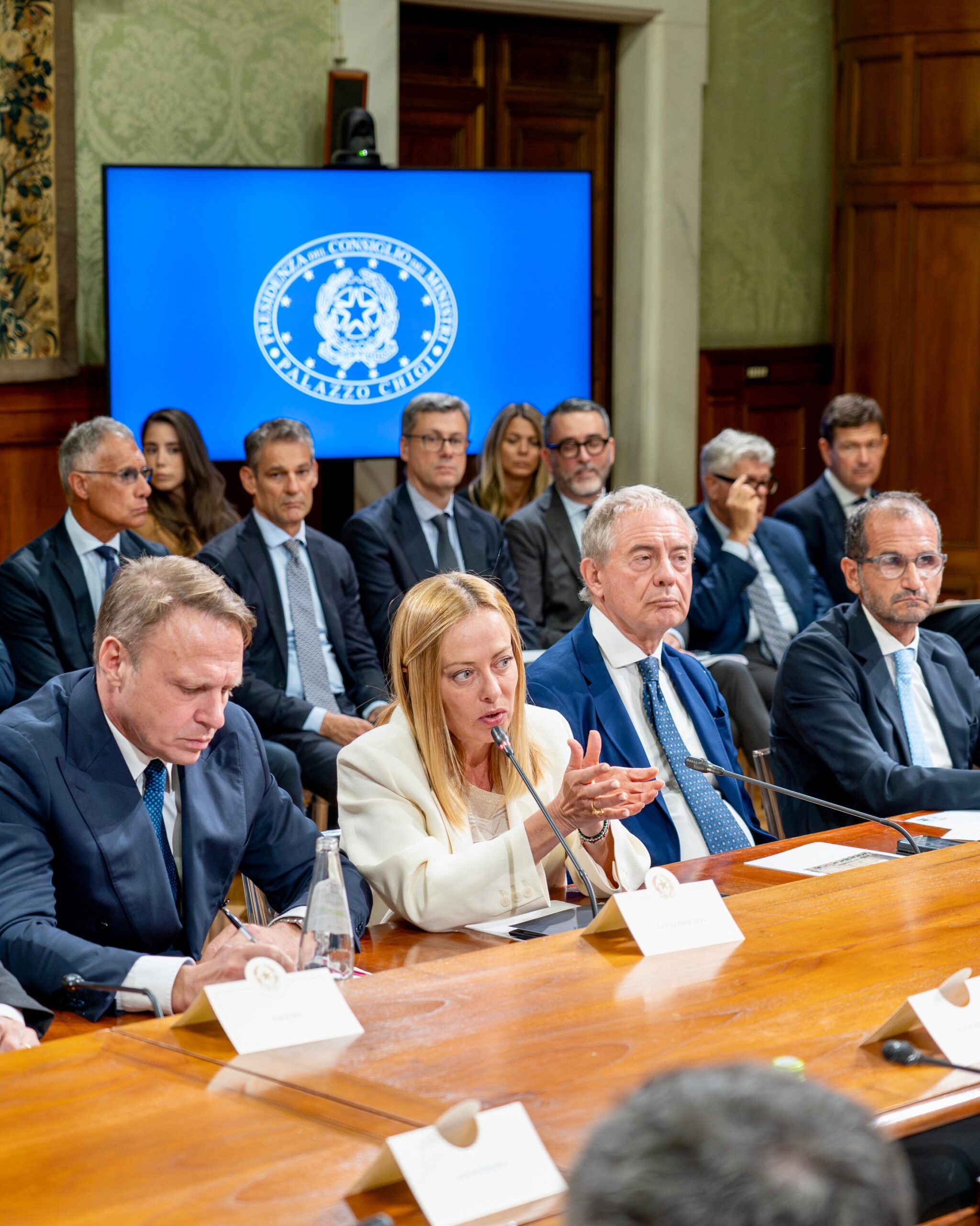 Il presidente del Consiglio Giorgia Meloni tra i ministri Francesco Lollobrigida e Adolfo Urso al tavolo tecnico sul vino